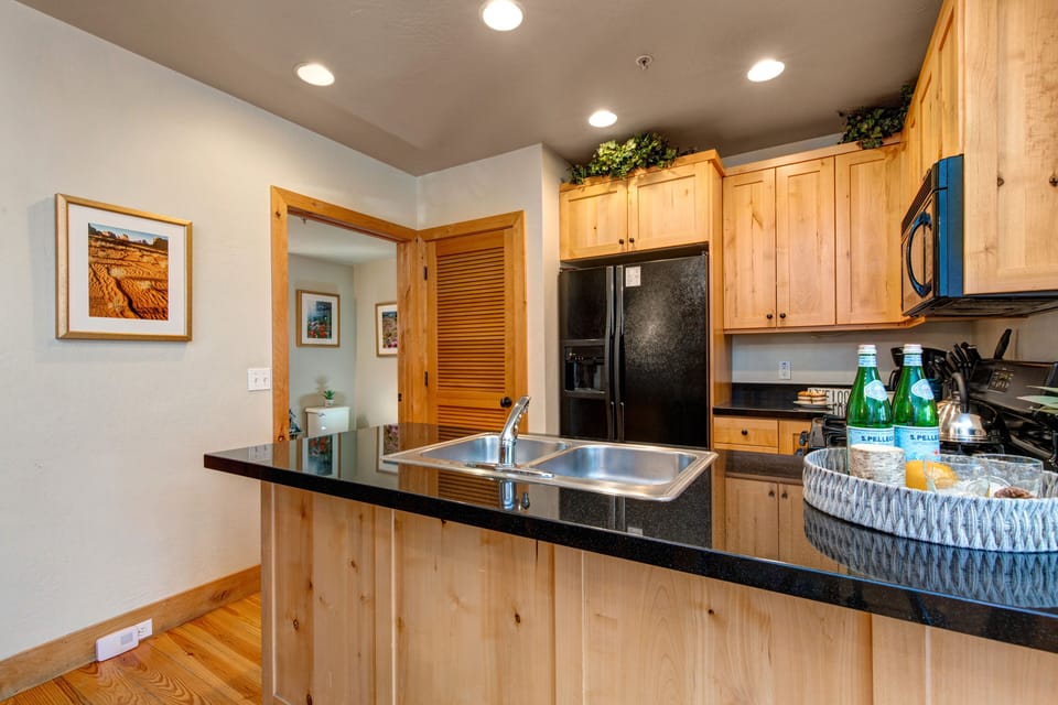 Fully Equipped Kitchen with gorgeous stone countertops, ice maker, private stacked laundry units, and shared full bath access