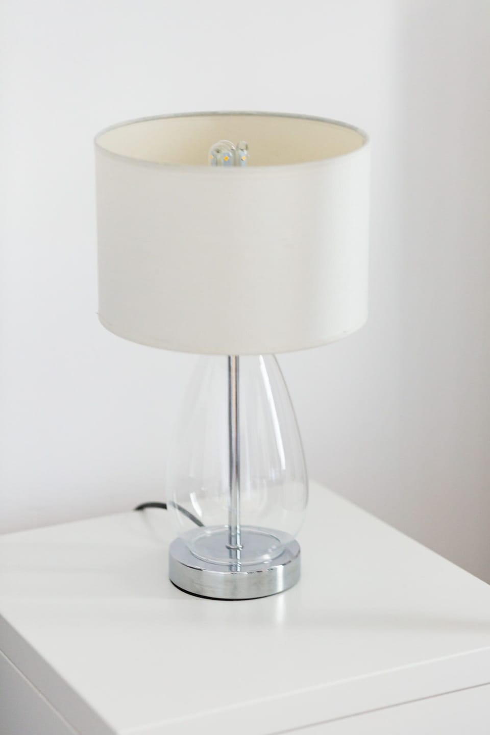Lamp on a white bedside table.