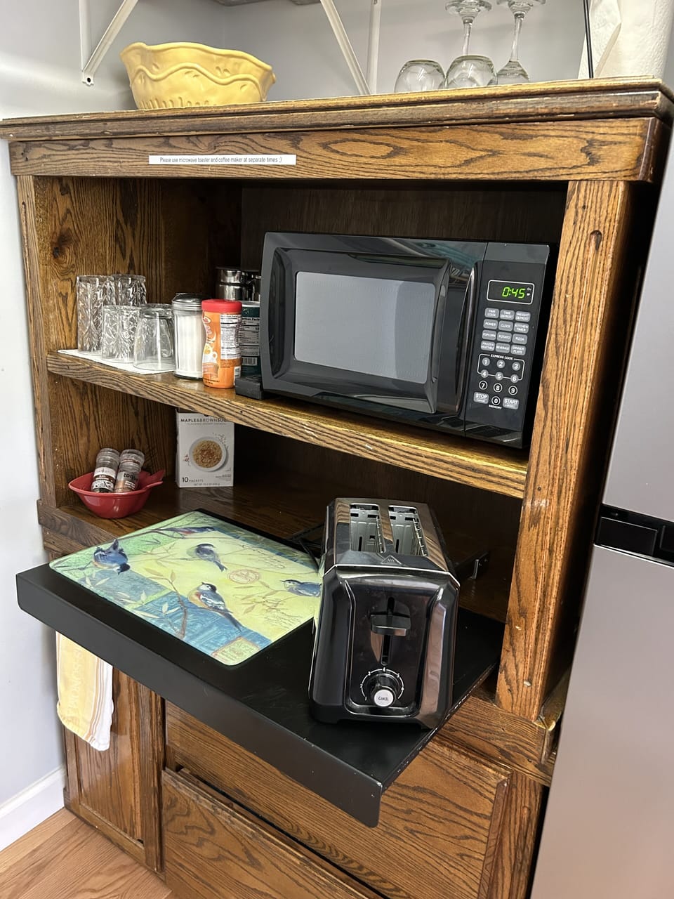 Prep area with microwave and toaster and fridge.
