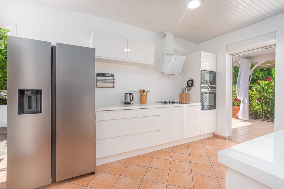 The kitchen of the Colibri Trotteur villa is totally functional, its openness on the living room and the outside make it a pleasant place to stay with the family.