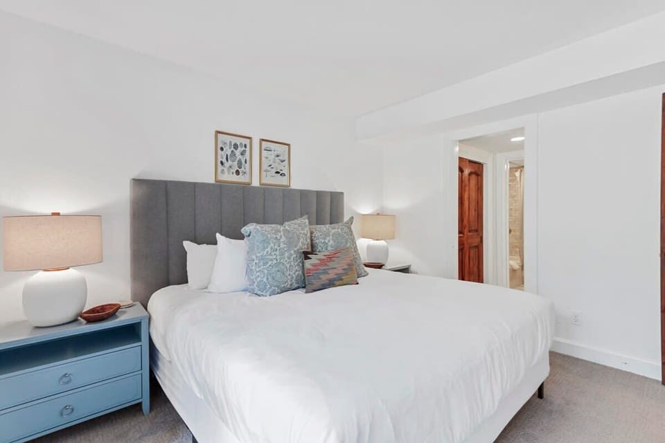 Lower level master bedroom with a comfortable king-size bed, a flat-screen TV, access to the outdoor deck, and an en suite bathroom