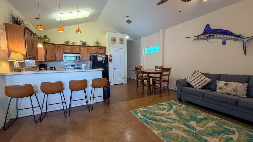 Your coastal retreat features an open kitchen, cozy dining space, and relaxing living area with nautical touches that make you feel at home.