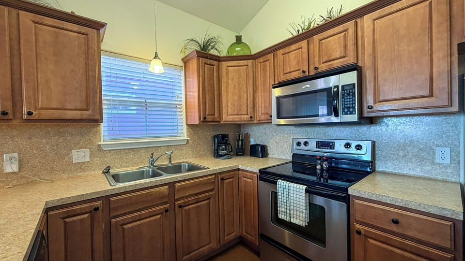 Cook memorable meals in your fully-equipped kitchen featuring warm wood cabinets, granite countertops, and modern appliances perfect for culinary adventures.
