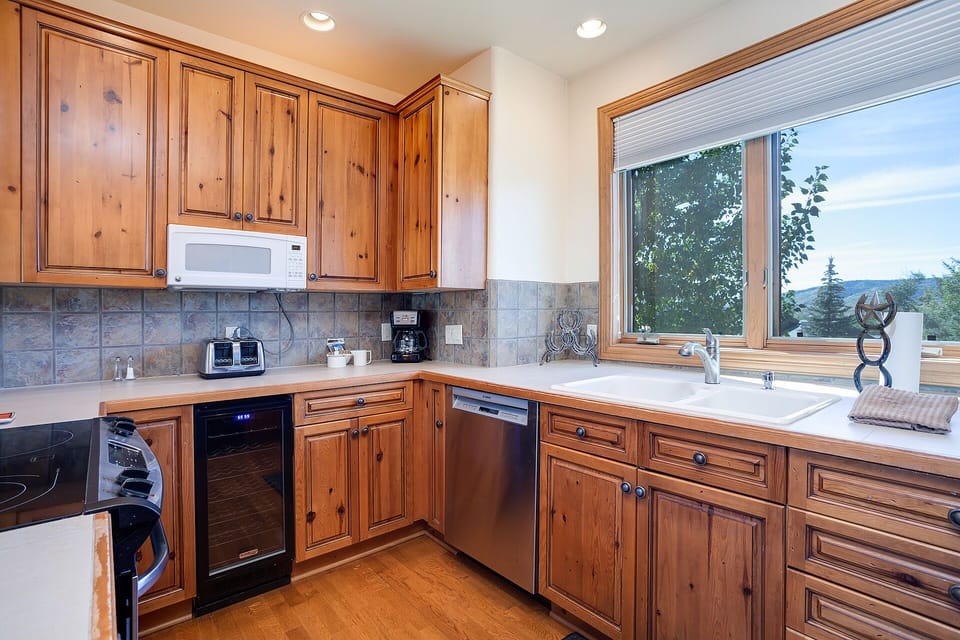 Your fully equipped kitchen features warm wood cabinetry and modern appliances, with mountain views to inspire your morning coffee routine.