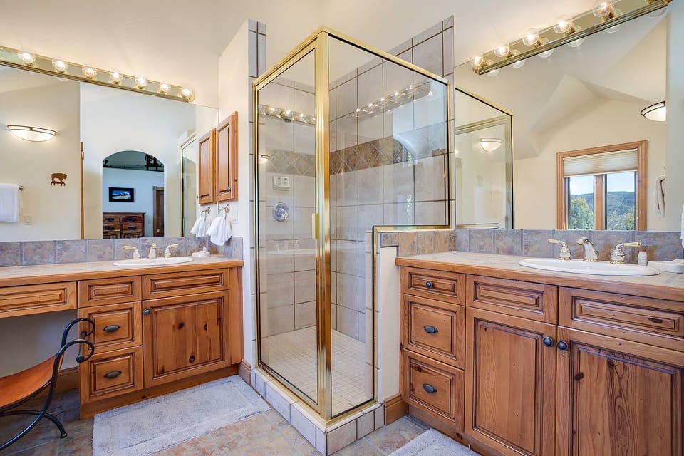 Dual vanities and a spacious walk-in shower await, offering comfort and convenience in your private retreat after a day of mountain adventure.