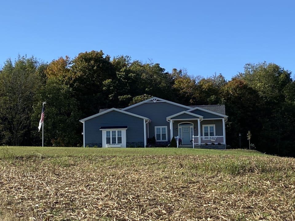 Our 2020 Craftsman on a hill overlooking corn, horses, beautiful trees and hills