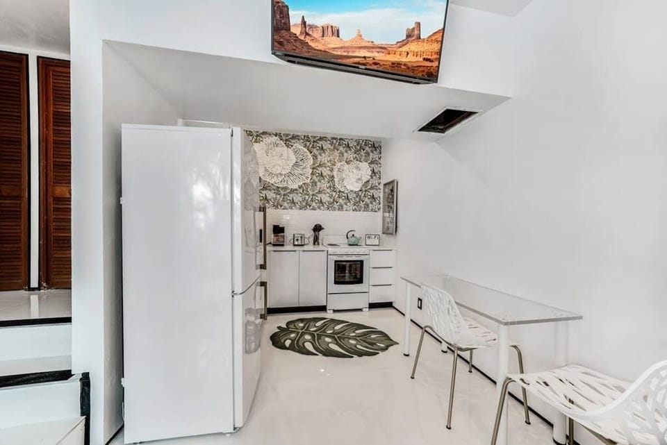 The kitchen is stocked with a full set of appliances including basic kitchen utensils. 