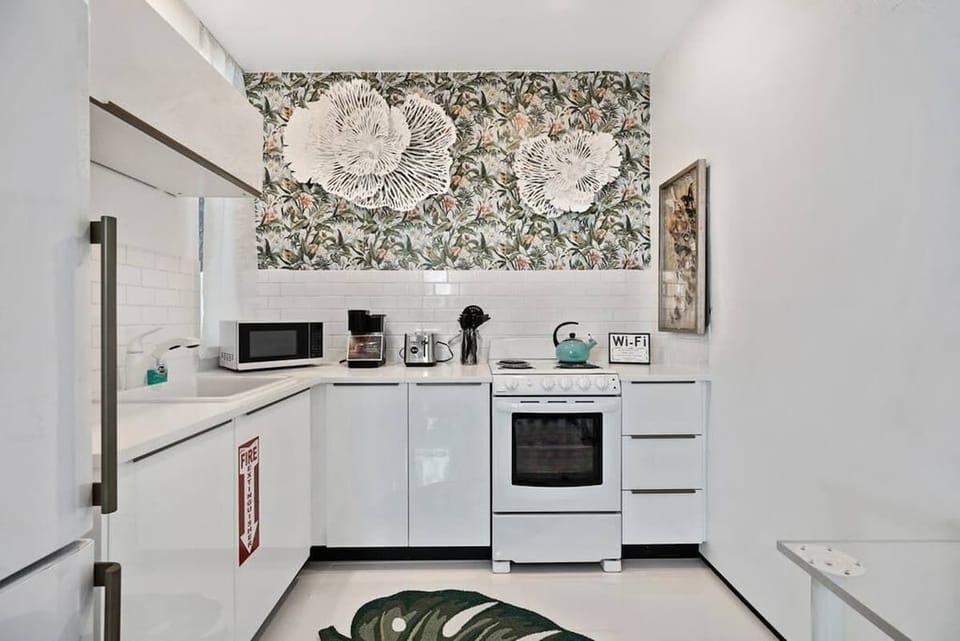 The kitchen is stocked with a full set of appliances including basic kitchen utensils. 