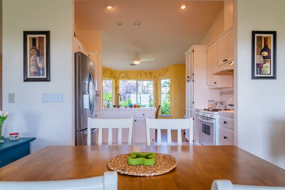 The dining table sits just outside the bright kitchen.