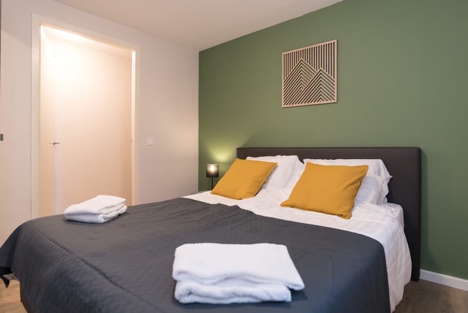 Peaceful bedroom featuring a comfy double bed and calming green tones for a restful night.