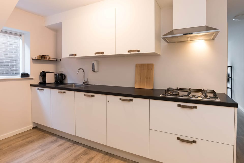 Fully equipped modern kitchen with Nespresso machine, dishwasher, fridge/freezer, and all essentials for home cooking.