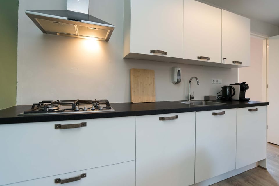 Fully equipped modern kitchen with Nespresso machine, dishwasher, fridge/freezer, and all essentials for home cooking.