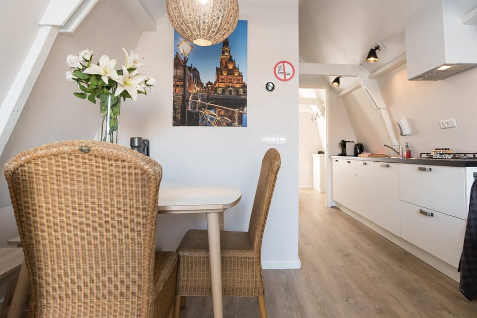 Charming dining area with rattan chairs and a cityscape artwork, adding a warm touch to your meals