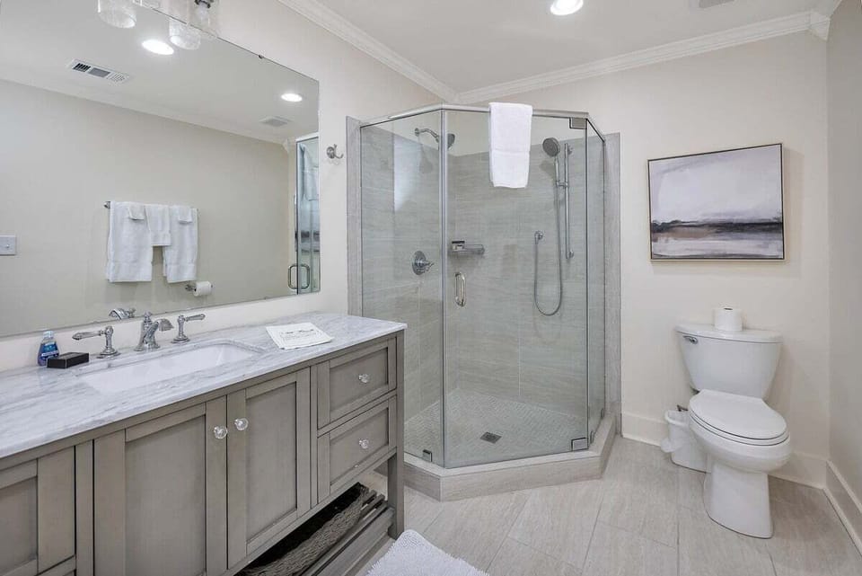 Bathroom with corner glass shower and gray double vanity
