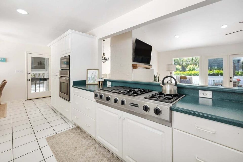 Kitchen with gas range, wall oven, and teal counters