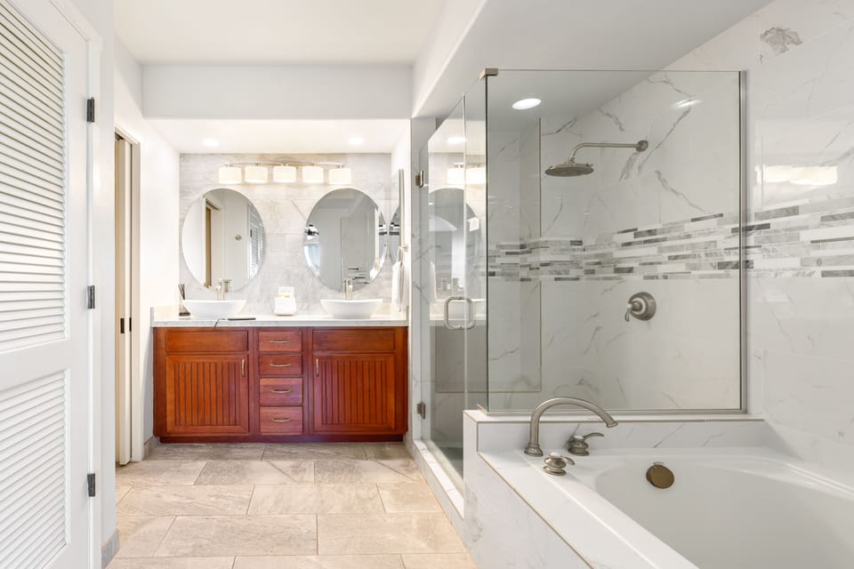 Ensuite primary bathroom with double vanity, walk-in shower, and soaking tub