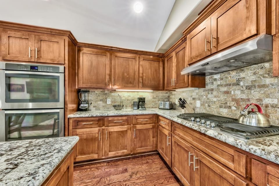 Your gourmet kitchen awaits with granite countertops, premium appliances, and warm wood cabinetry—perfect for creating memorable meals during your stay.