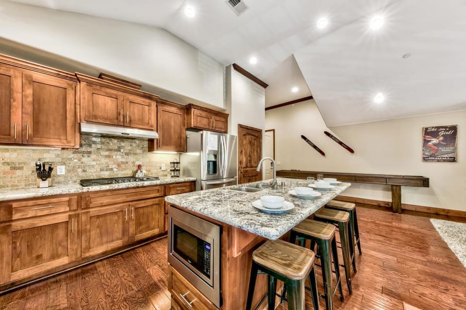 You'll love cooking in this spacious kitchen with granite counters, rich wood cabinets, and a perfect island for gathering with friends.