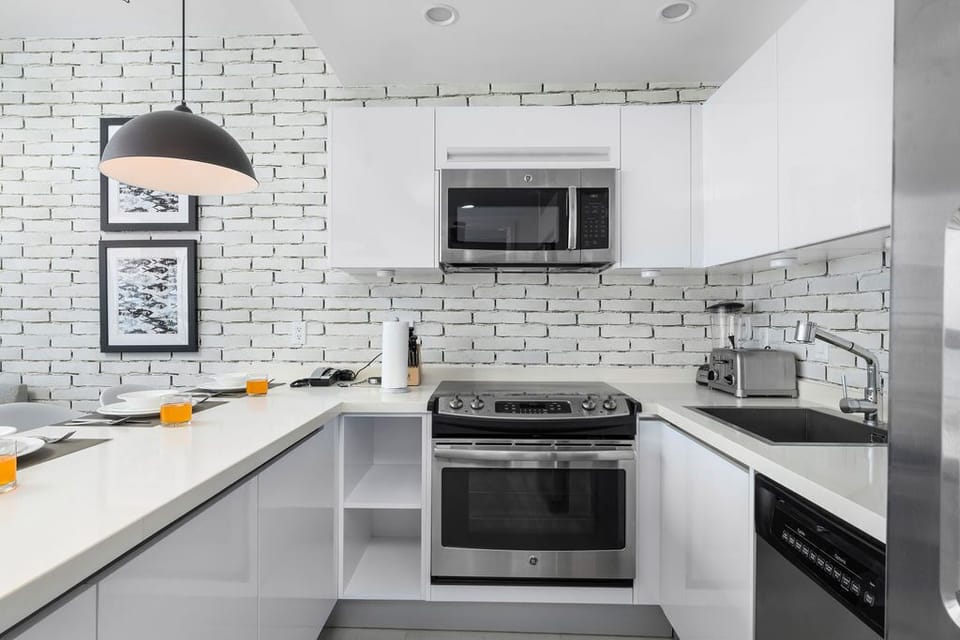 Your modern kitchen features sleek white cabinetry, a full-size oven and stove, plus a microwave—perfect for preparing everything from quick snacks to memorable home-cooked meals.