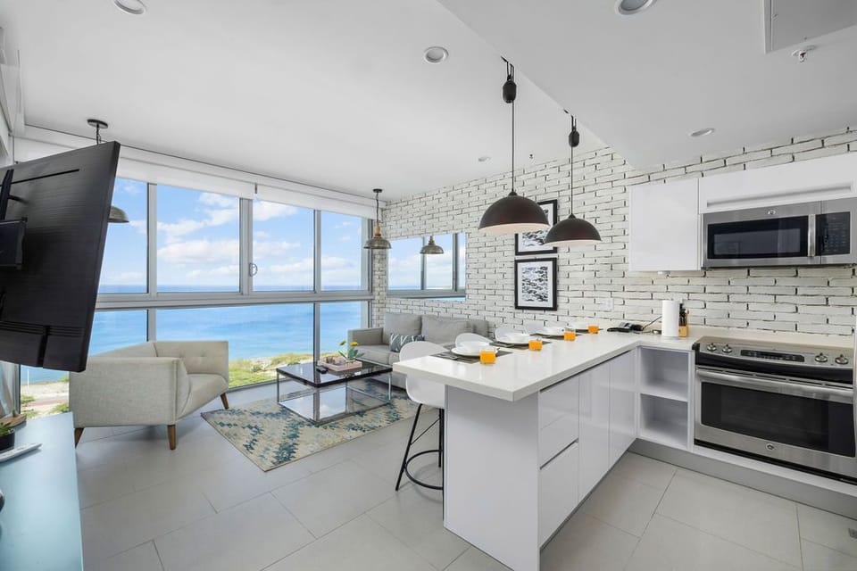 Bright, modern open-concept space where you can cook in your fully equipped kitchen while enjoying stunning sea views. Relax on the cozy living room sofa and soak in the coastal scenery.