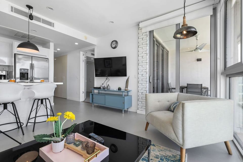 Relax in your bright, modern living space with stylish mid-century accents, sleek open kitchen, and private balcony access—perfect for unwinding after exploring the area.