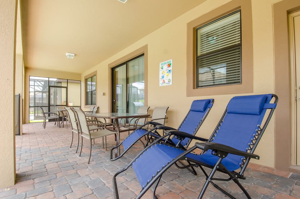 Pool side covered Patio with 2 glass tables and 12 chairs