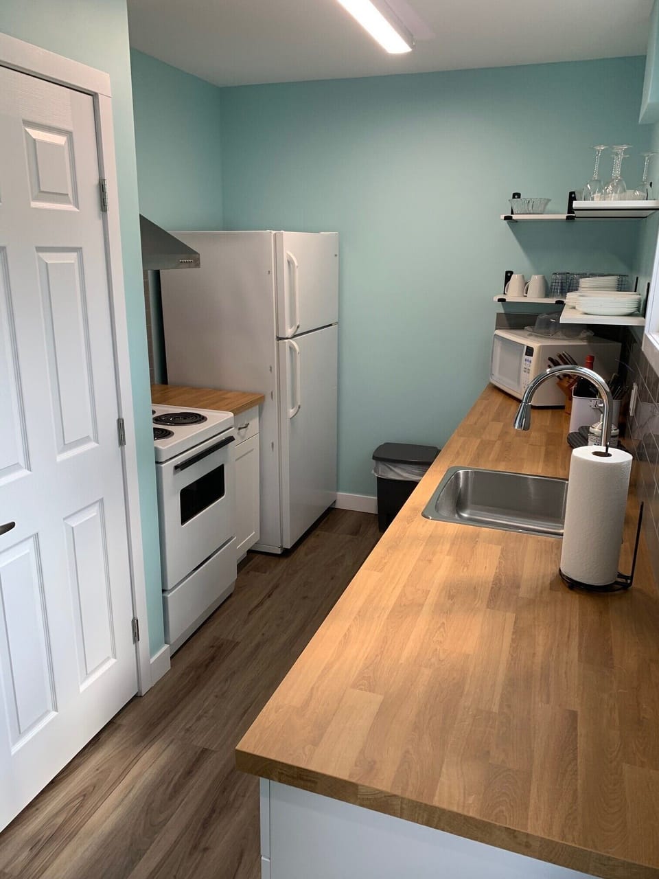 the kitchen features 3 appliances and cabinet storage