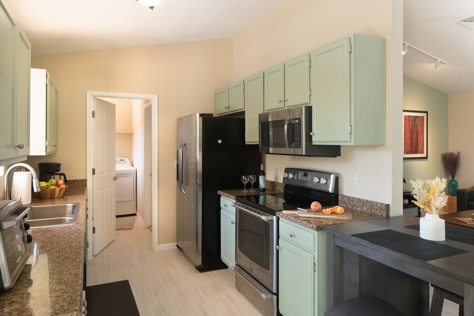 Kitchen has microwave, range, oven, toaster, regular coffee pot, fridge, storage