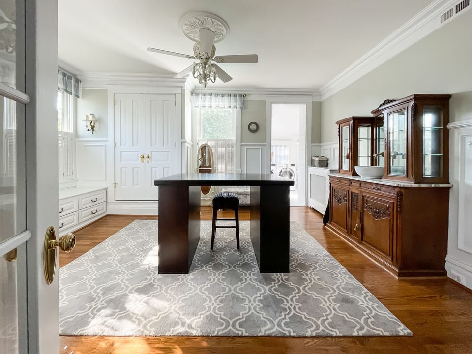 The Bees Knees (Mill Haus) primary bedroom has a king size bed with crisp white linens, a nonworking fireplace accent, and an en suite bathroom with an amazing dressing room with delicious natural light.