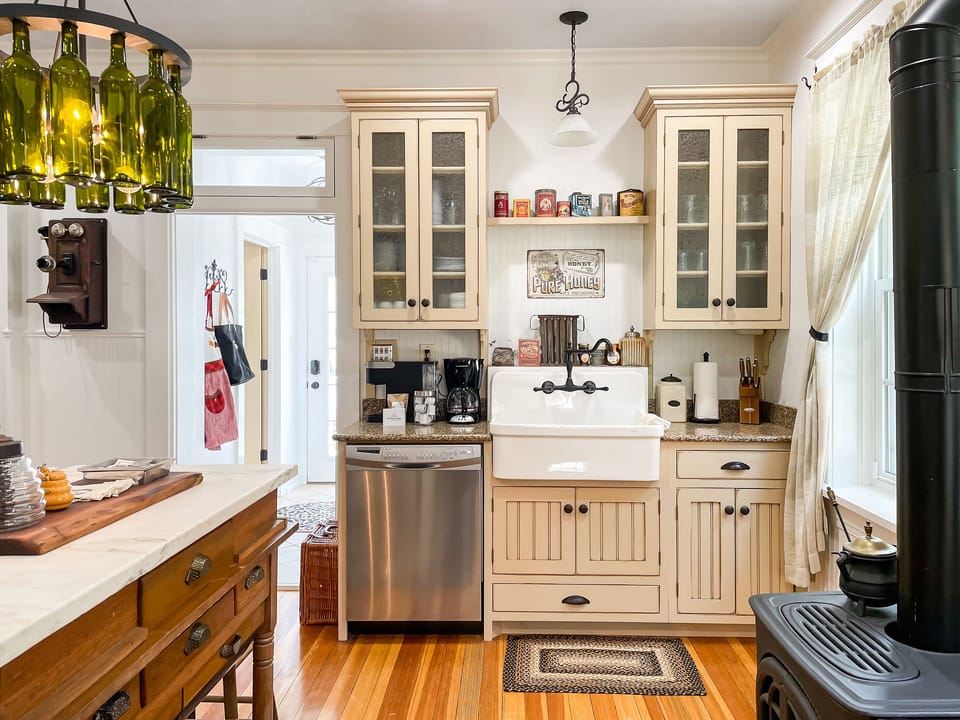The beautifully detailed full kitchen has everything you need to make your own meals, including place settings, pots and pans, wine glasses, and a regular coffee maker or a Keurig at the Bee's Knees (Beekeeper's Cottage).