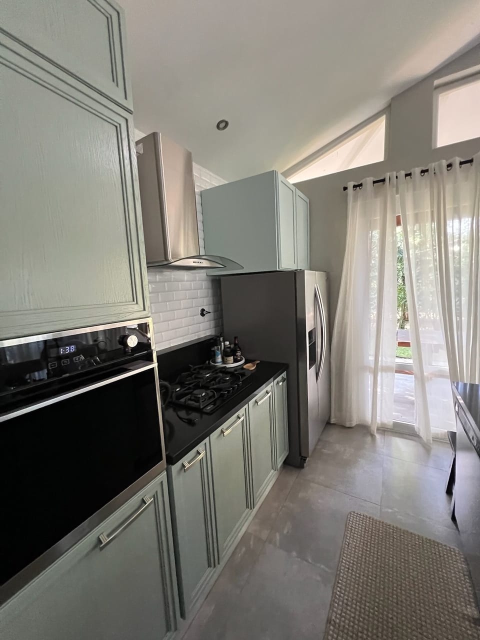 Kitchen with extractor, stove top gas and oven, microwave, & fridge