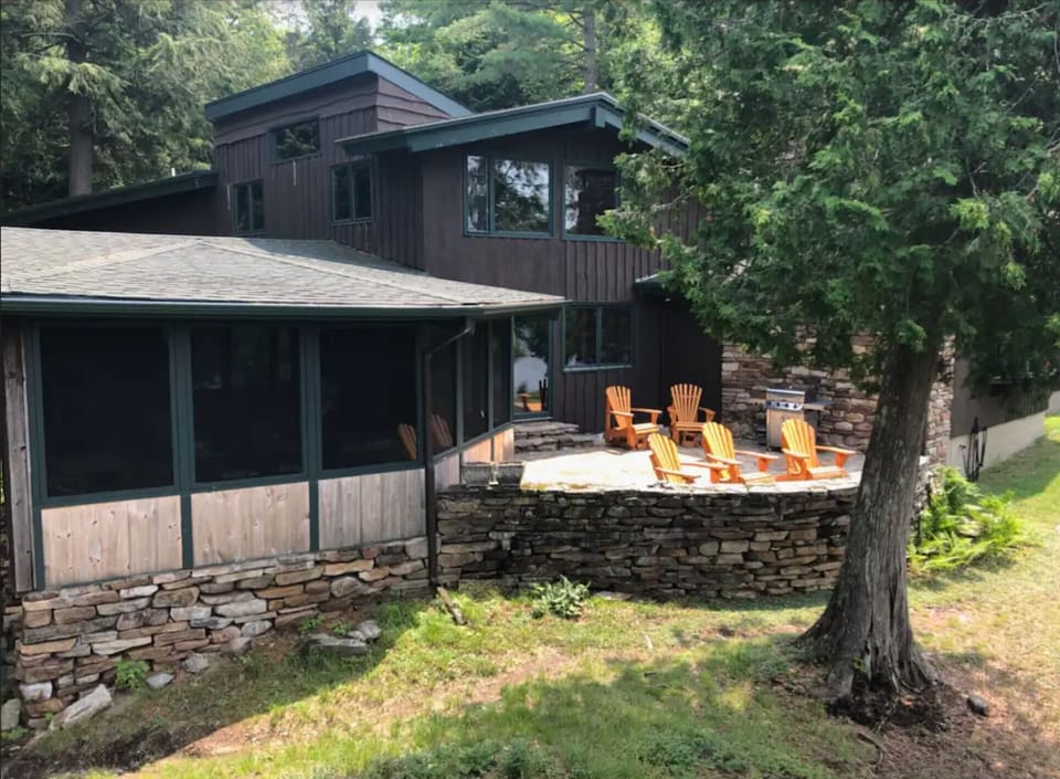 Stone patio with gas grill facing lake.  