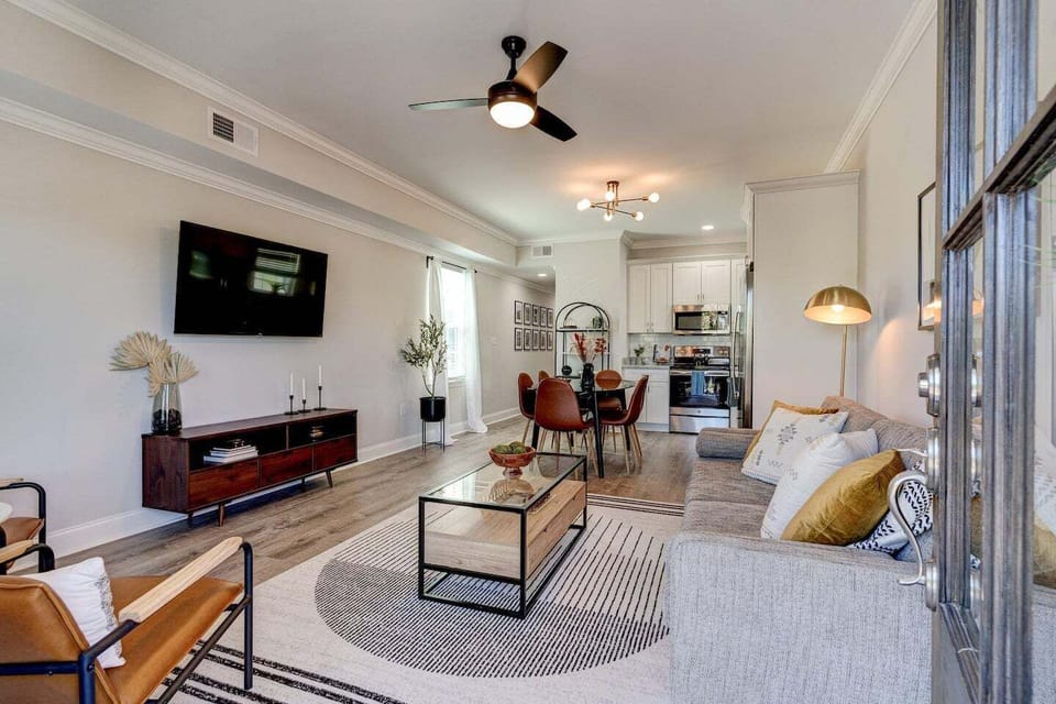Bright and inviting open-concept living area with modern furnishings, stylish accents, and a seamless flow into the dining and kitchen space.