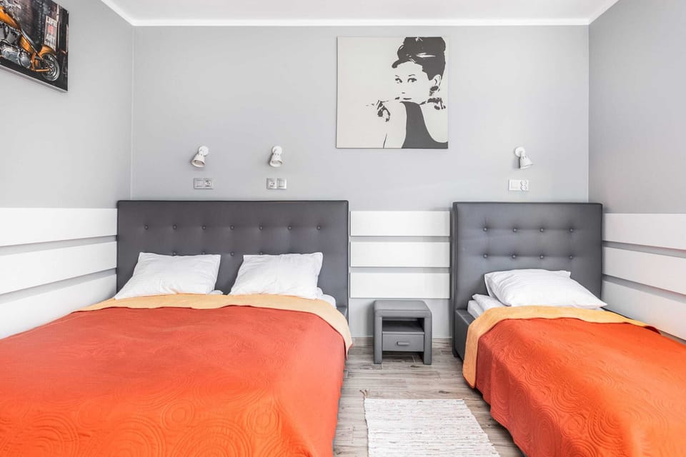 A bright and comfortable bedroom in shades of grey, a double bed and a single bed.