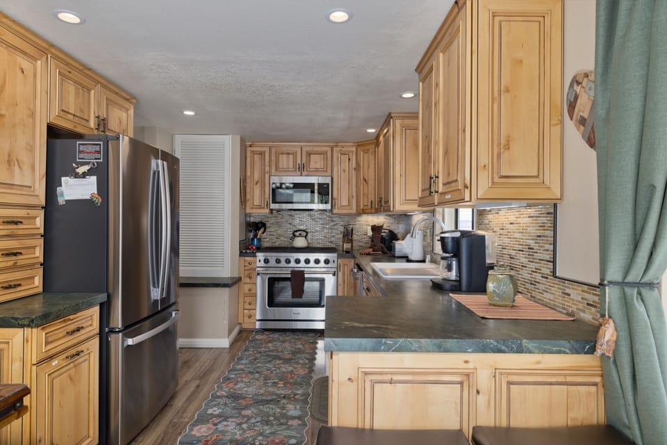 Your fully equipped kitchen invites you to prepare your favorite meals with premium stainless appliances, generous counter space, and warm wood cabinetry throughout.