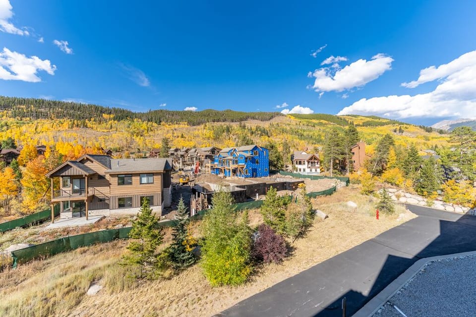 Mountain community surrounded by golden aspen forests and alpine peaks under brilliant blue skies.