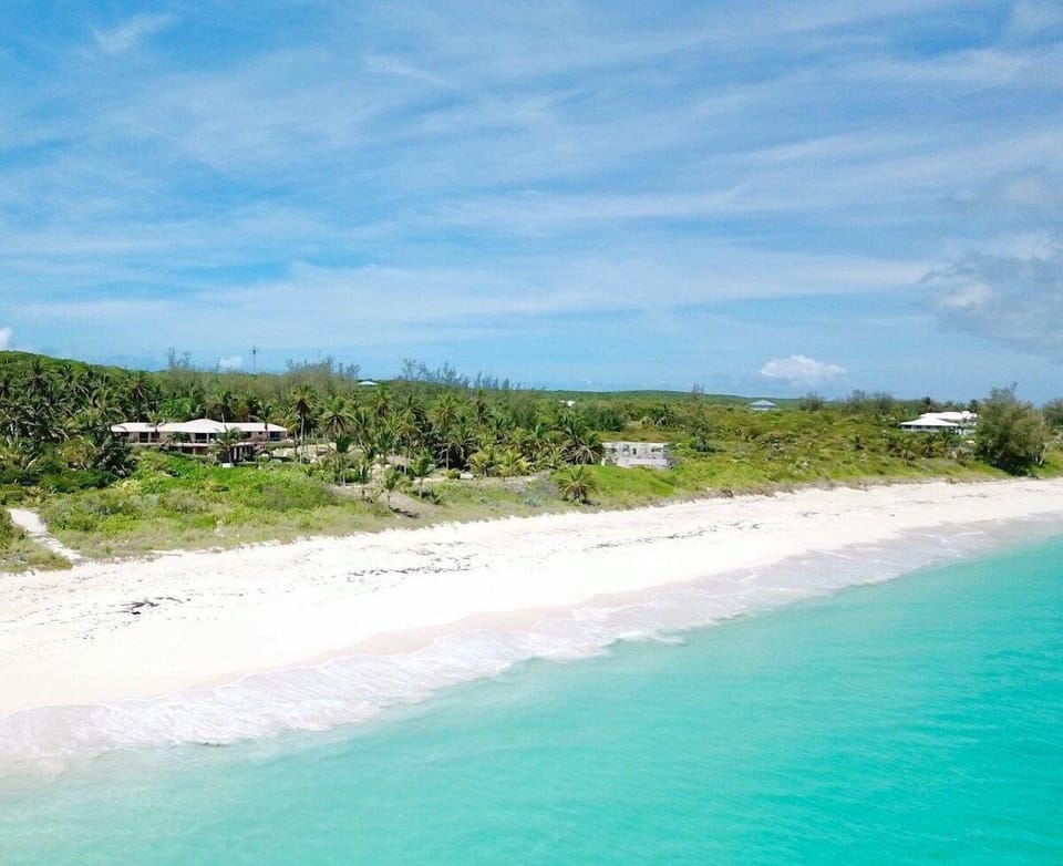 This private estate looks out over a pristine, mile-long pink-sand beach.