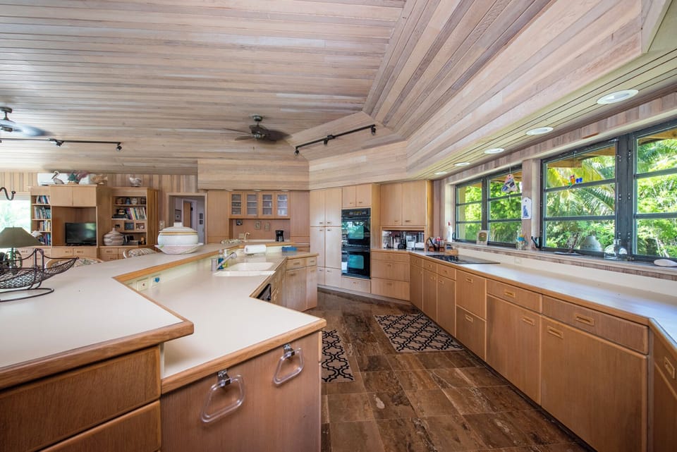 Luxurious island kitchen is equipped with a Sub-Zero refrigerator, glass-top range, wall oven, dishwasher and microwave.