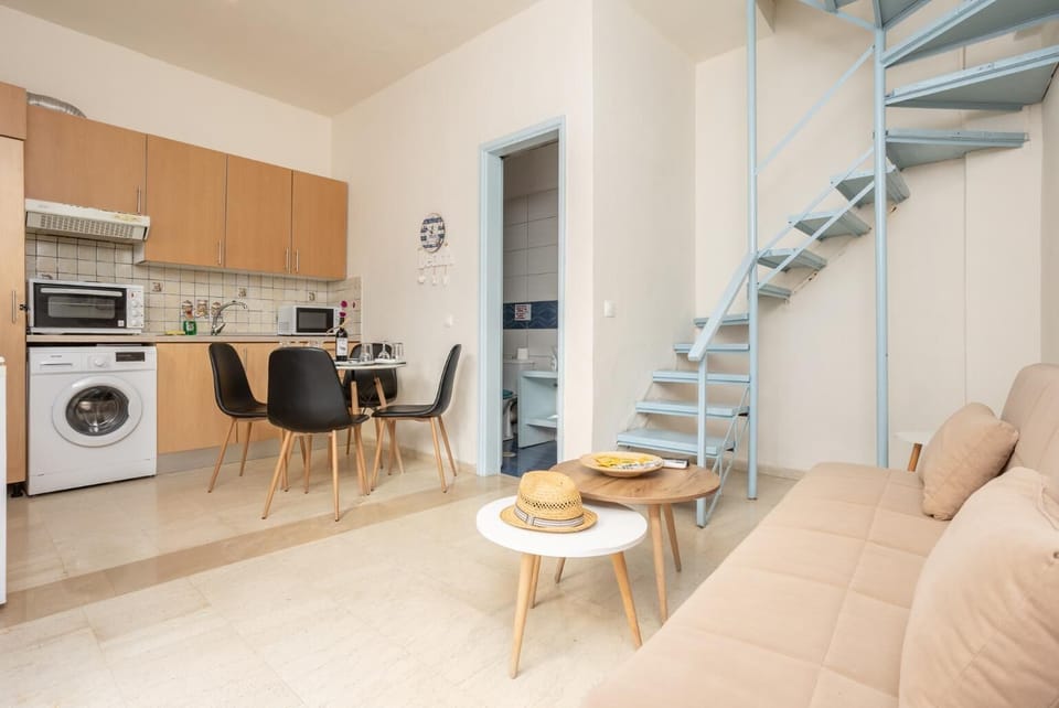 Open-plan living room with sofa, dining area, kitchen, A/C, WiFi internet, and satellite TV