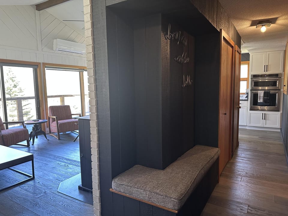 Welcoming entryway with cushioned bench and wall hooks.