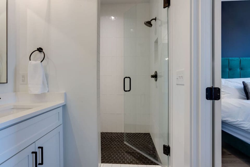 Walk-in shower with tile walls, glass door, and modern fixtures