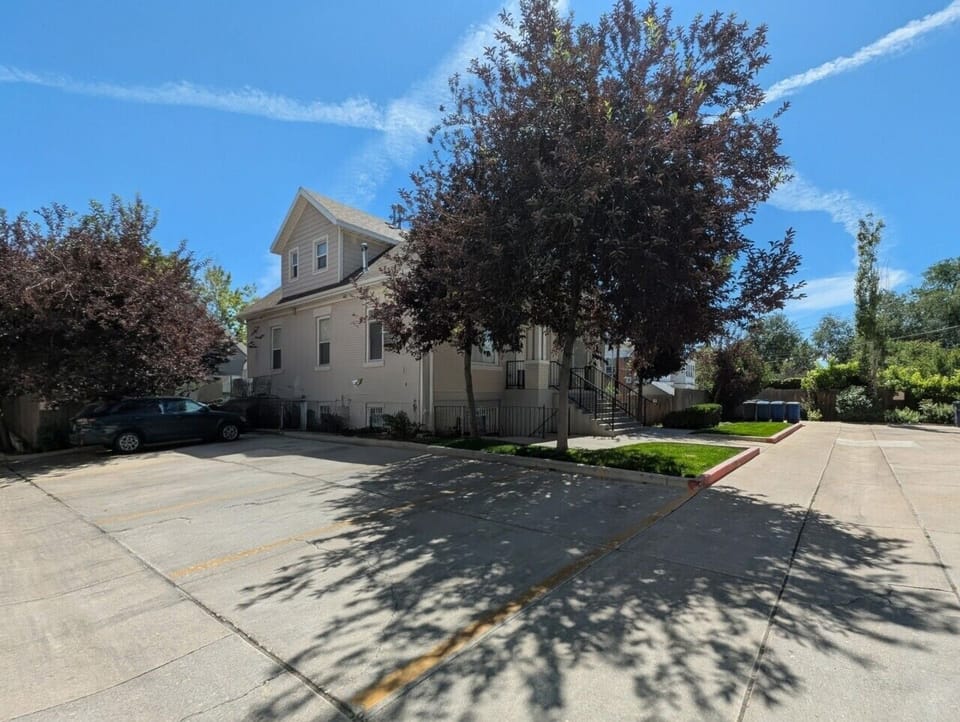A clear view of the parking layout and assigned spaces. The lot contains five single parking spaces serving the apartment building and provides convenient access to the unit entrances.
