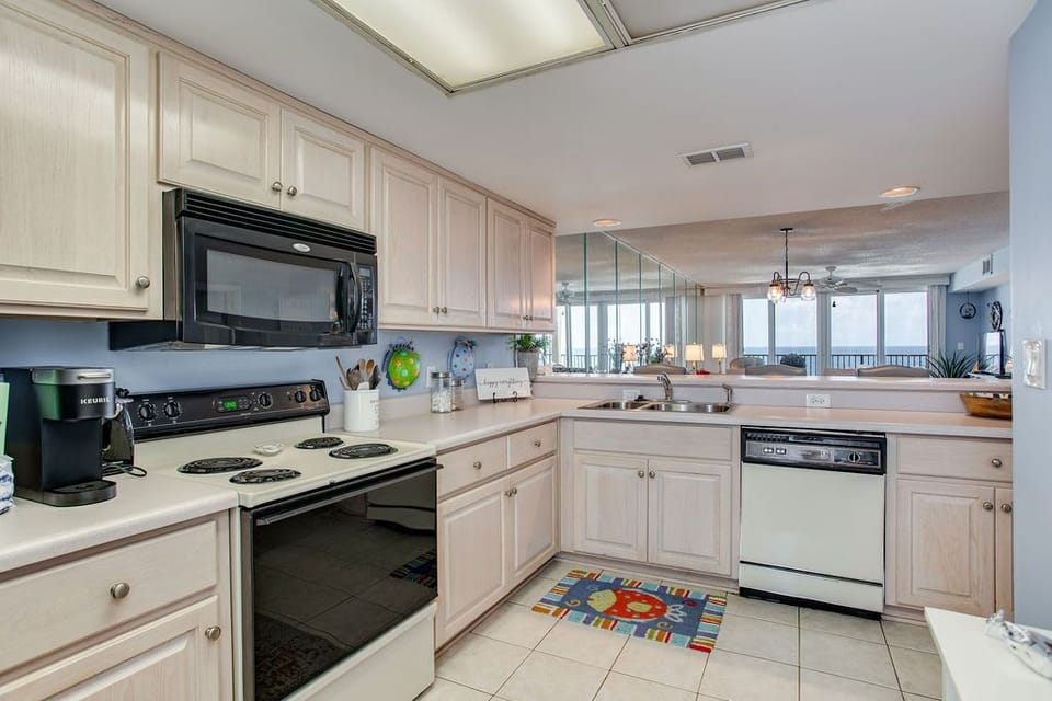 Fully equipped kitchen with white cabinets at Wind Drift Orange Beach vacation rental