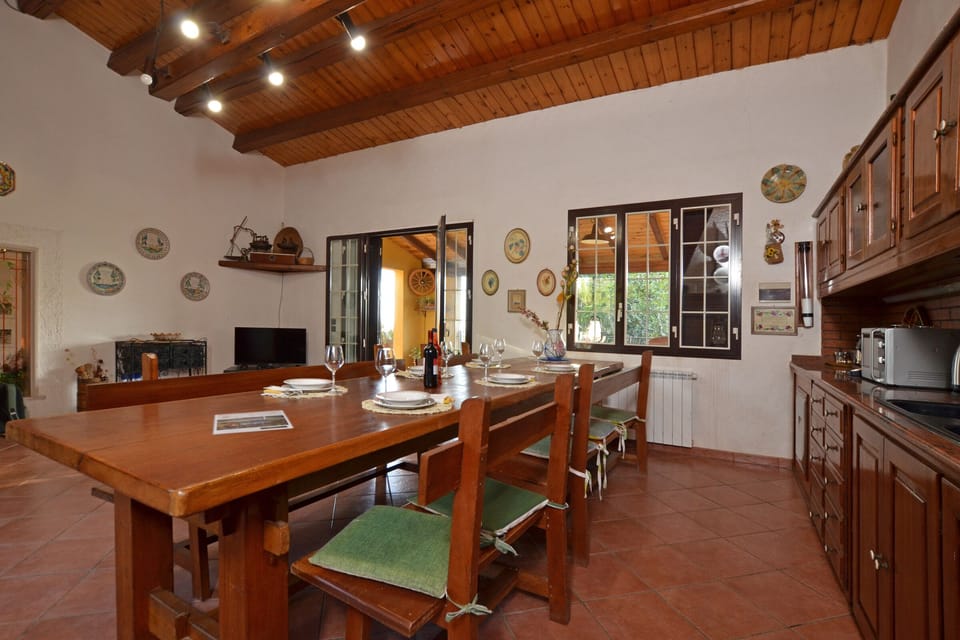 The wide kitchen with the dinner table, open on both side of the Villa
