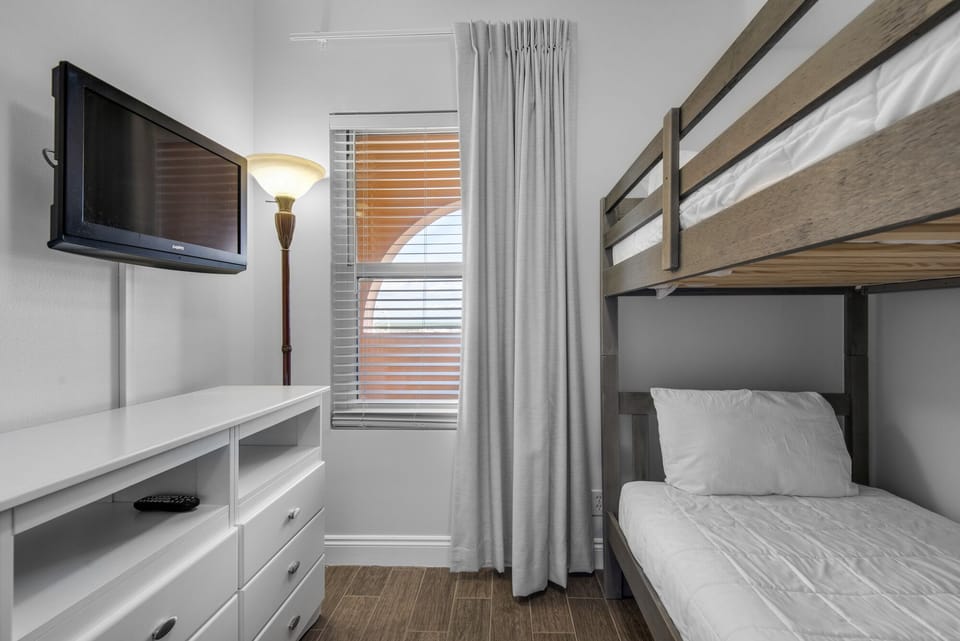 Third Bedroom - cheerful retreat for little ones or friends, this third bedroom has bunk twinbeds, a TV, and ample space to unwind.