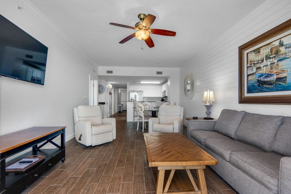 Living Room -Luxury and comfort meet in this beachfront living room with plush seating, a large flat-screen TV, and stunning ocean views through floor-to-ceiling windows.