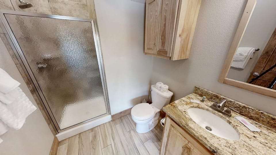 Step into your private bathroom, where warm wood finishes meet elegant granite countertops. Enjoy a refreshing shower with fresh towels waiting, all within a thoughtfully designed space that feels like home.