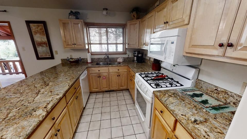 Step into your fully-equipped kitchen with granite counters, gas stove, and everything you need to whip up a home-cooked meal during your mountain getaway.