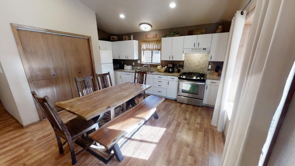 Gather around the farmhouse-style dining table in your fully equipped kitchen, where natural light streams in and everything you need to cook a delicious meal is right at your fingertips.