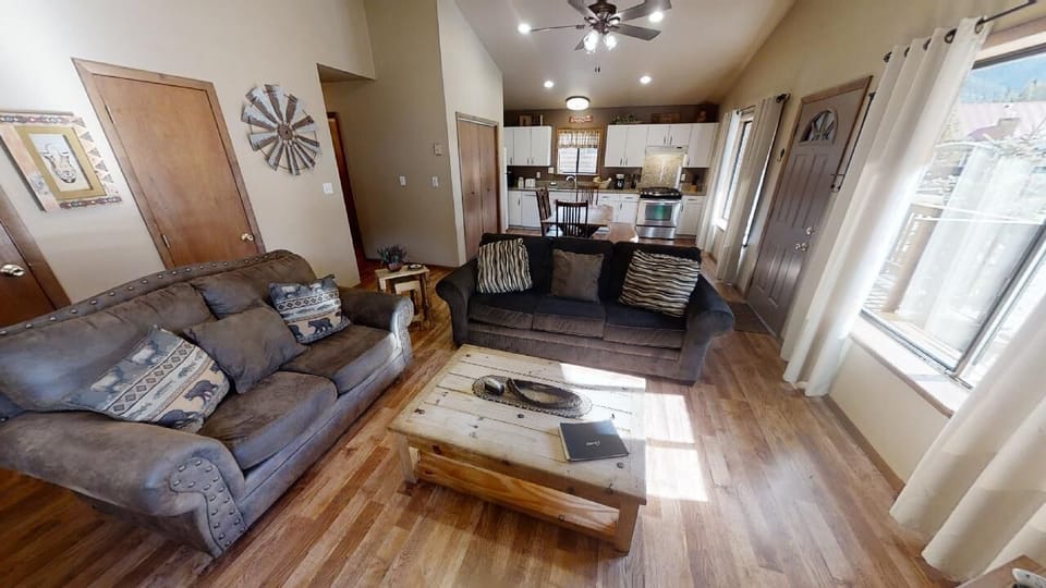 Unwind in your inviting living space with plush seating, warm wood floors, and sunlit windows. The open layout flows seamlessly into the well-equipped kitchen, perfect for gathering and making memories.